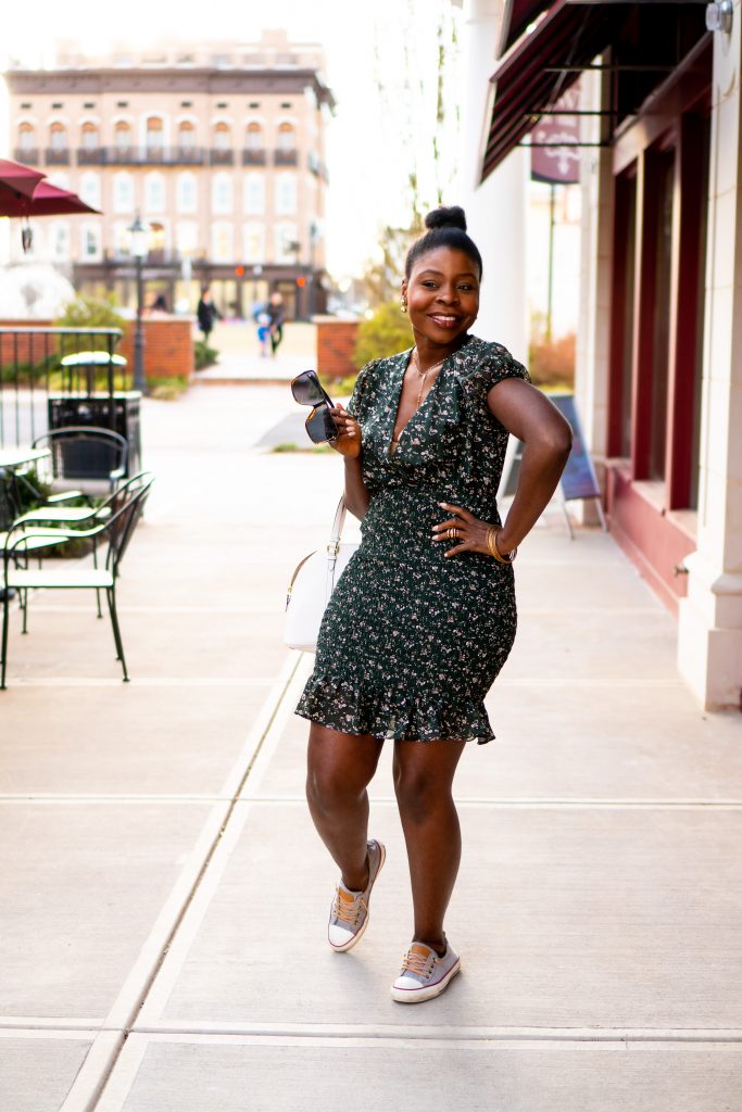 Woman wearing a flower dress standing on sidewalk