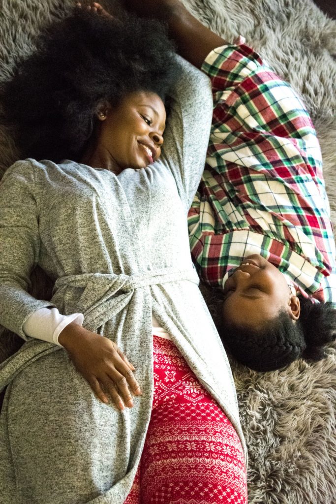 woman and girl lying down on the floor together
