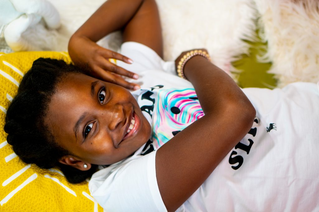 Child lying on a yellow pillow smiling