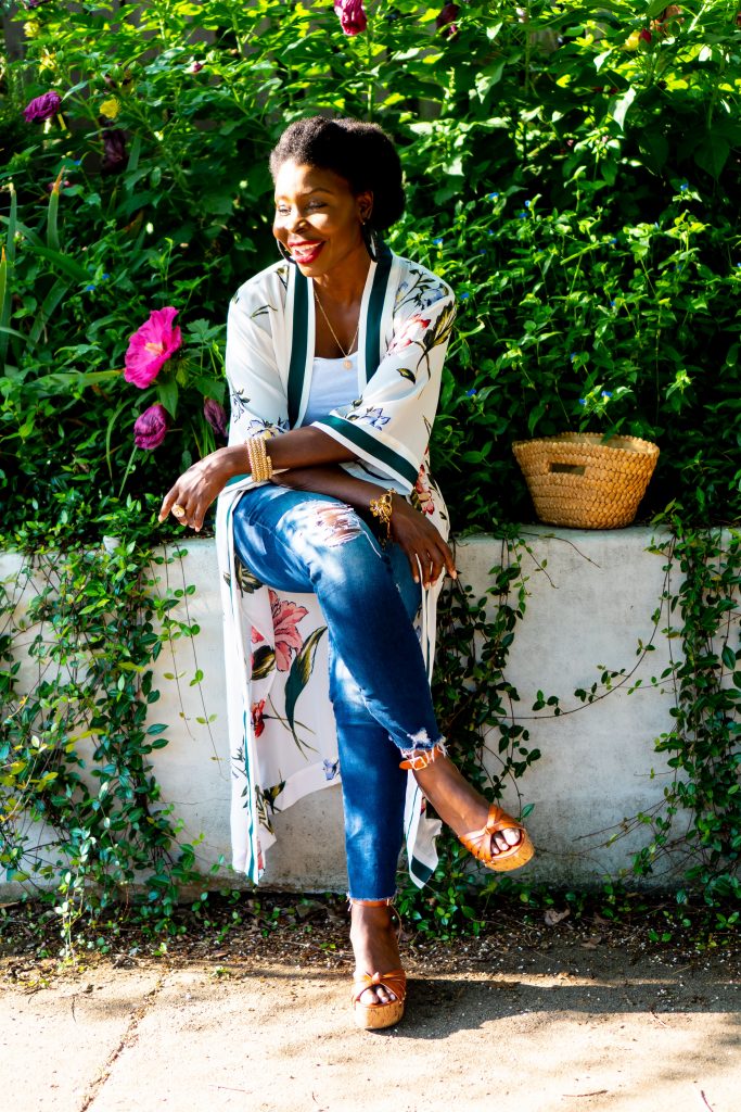 woman sitting on a wall with running vines