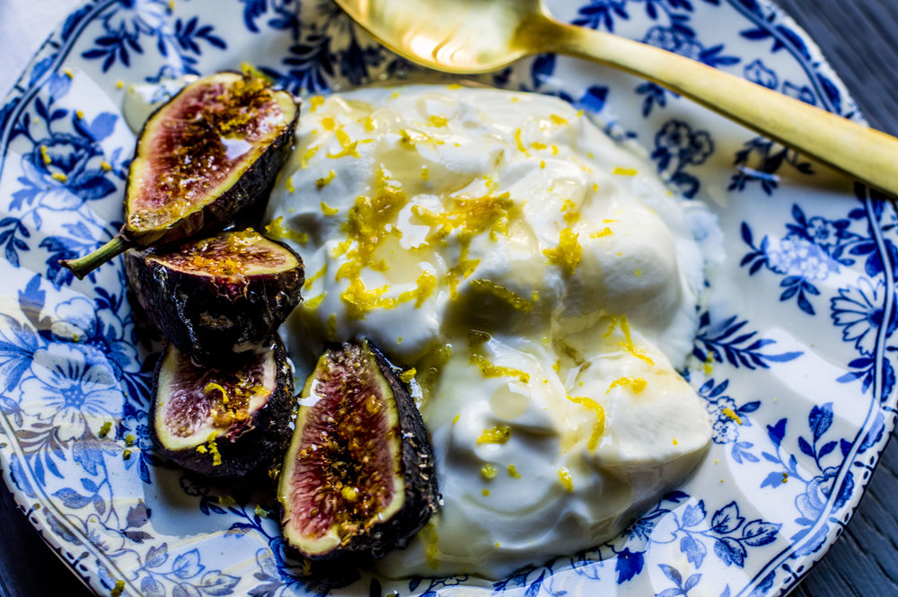 blue plate with yogurt and figs and a gold spoon