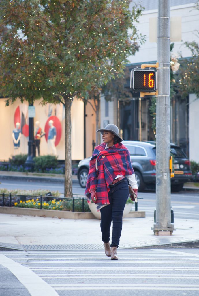woman wearing plaid scarf crossing the street