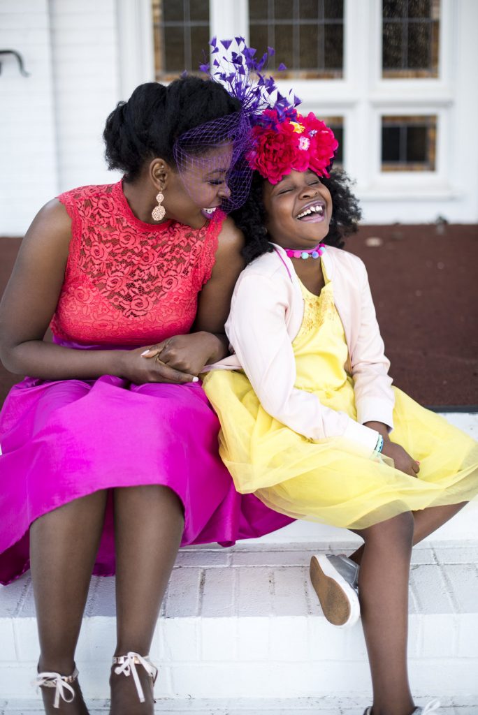 woman and girl sitting on steps laughing