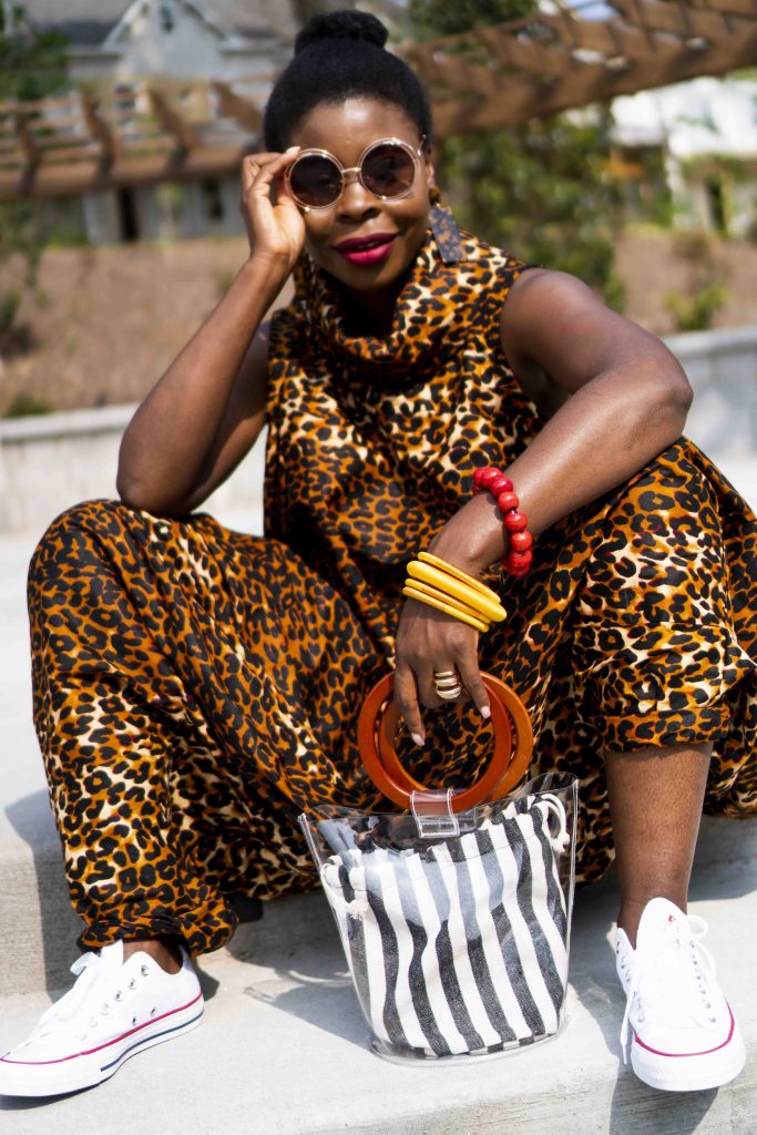 Herem Jumpsuit styled by top Atlanta fashion blogger, Hurry in Time: woman wearing leopard jumpsuit holding her shades