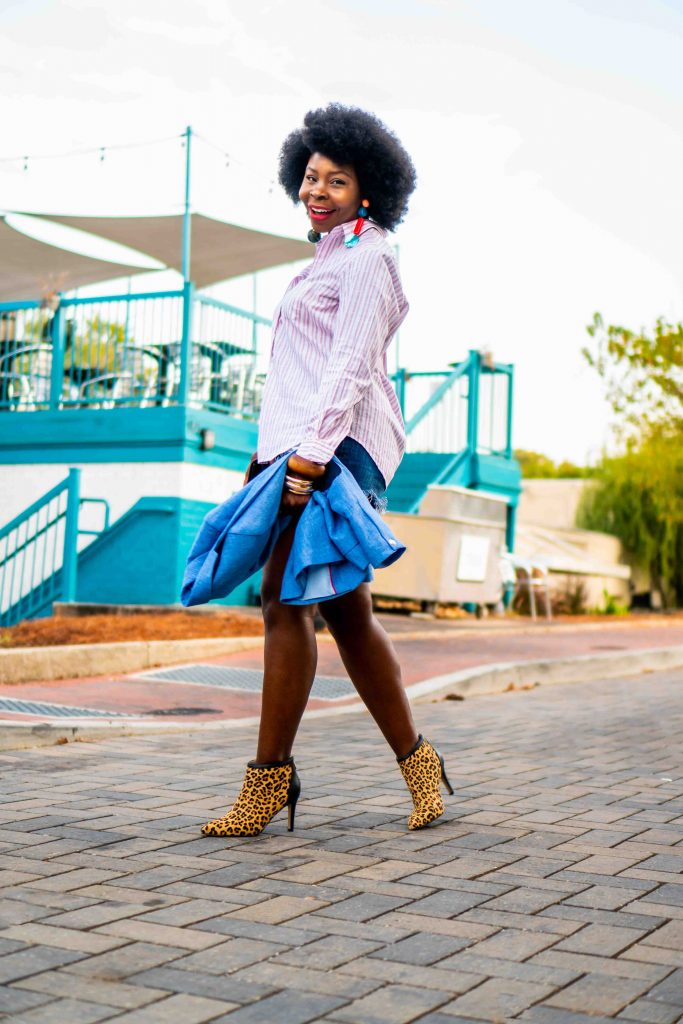 lady wearing an afro with a jacket in her hand.
