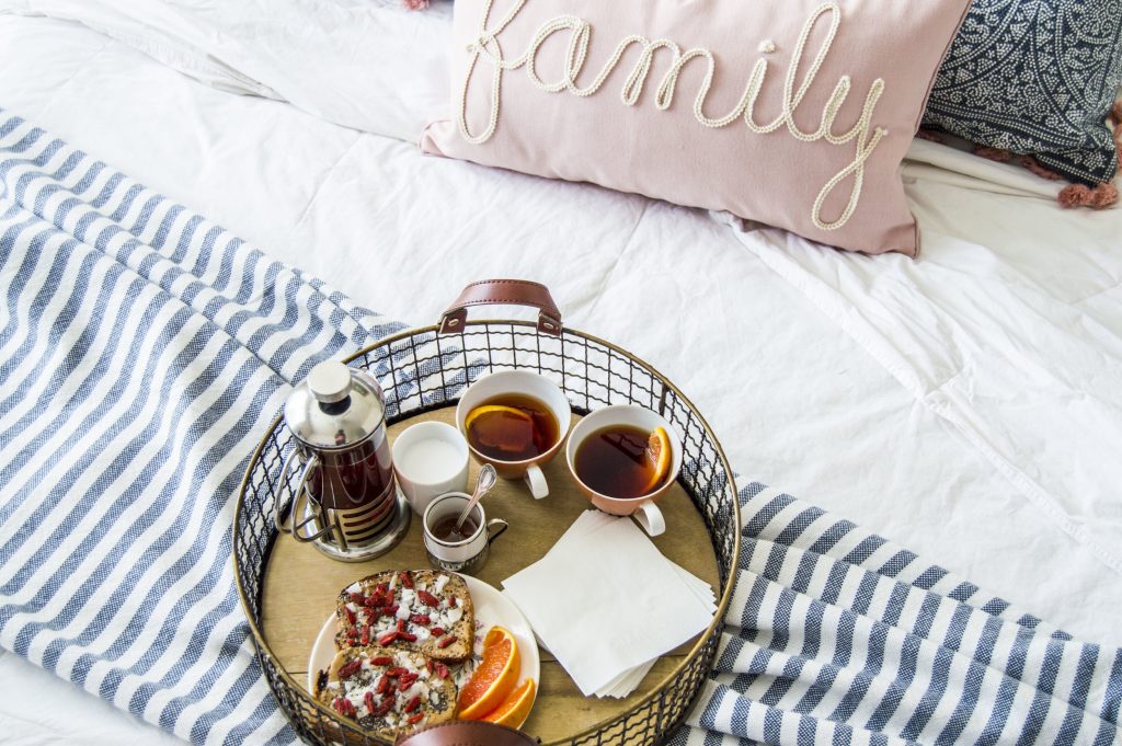Tea tray on a bed with decor pillows