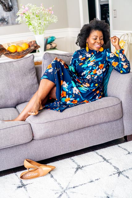 Woman in a floral dress sitting on sofa