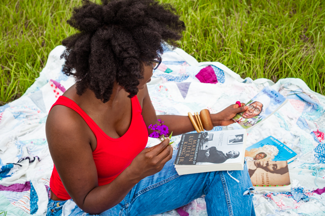 woman sitting on a blanket in a grass field